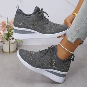 Gros plan de baskets grises à plateforme avec strass, maille et semelle compensée.
