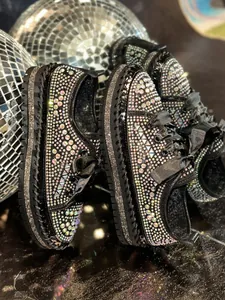 Close-up of black platform loafers fully embellished with shimmering colorful rhinestones