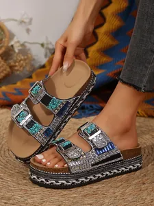 Detail of women's platform slippers with colorful rhinestones and buckle strap design