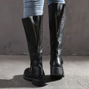 Detailed back view of black high-top knight boots with brass zippers and buckles