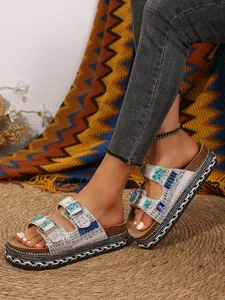 Detailed view of women's thick platform slippers with rhinestones and hemp rope sole.