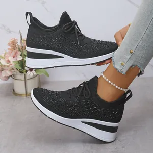 Détail de profil des baskets à talons compensés avec strass noirs et lacets pour femmes