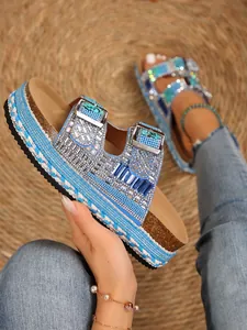 Close-up of blue rhinestone platform sandals with double buckles and braided rope