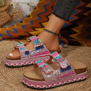 Dettaglio dei sandali platform con strass rosa, suola in sughero e doppia fibbia.