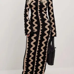 Abito lungo in maglia slim con motivo a onde nero e beige per la primavera.