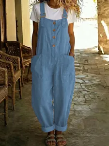 Detailansicht der blauen Baumwoll-Leinen-Latzhose mit Vintage-Knöpfen und großen Taschen