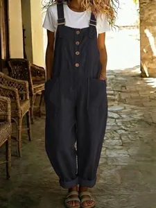 Ganzkörperansicht der schwarzen Vintage-Baumwoll-Leinen-Latzhose für Damen in einer Gasse