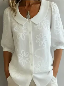 Detailed view of white floral embroidery on retro short sleeve button-down blouse