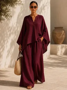 Ensemble bordeaux avec haut col en V et pantalon large sous une lumière chaude d'été.