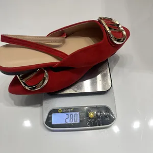 Macro shot of red suede flat shoes with gold buckle on a digital scale weighing 280g