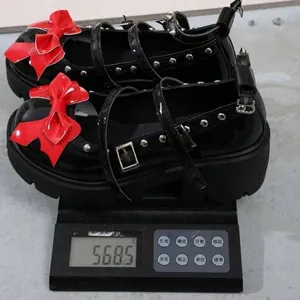 Detailed view of platform Mary Jane shoes with red bow on a digital scale weighing 568.5g
