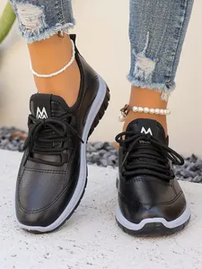 Detailed view of black women's platform sneakers featuring white logo and lace-up design