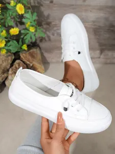 Detail view of white women's casual sneakers with lacing and durable thick soles