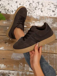 Gedetailleerd overzicht van donkerbruine retro GAT-sneakers met klassieke gomzool.