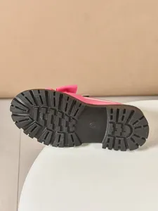 Detailed view of the durable black rubber lug sole on a pink platform bow loafer