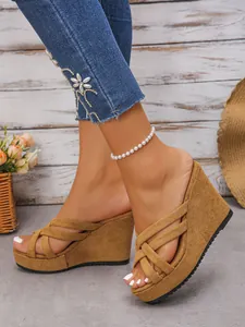 Détail des sandales compensées en daim pour femmes avec lanières croisées et plateau.