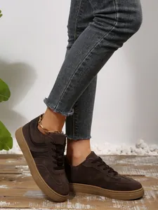 Close-up van modieuze retro bruine sneakers gedragen met een stijlvolle distressed denim jeans
