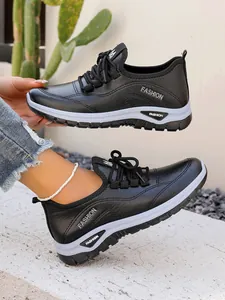 Detail of women's black platform sneakers with white soles and lace-up design