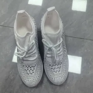 Vue détaillée de baskets blanches à lacets ornées de strass brillants et élégants.