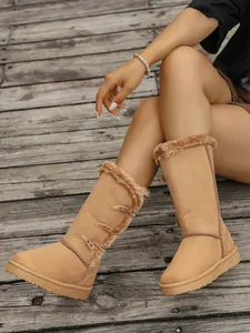 Close-up of women's camel snow boots with warm faux fur lining and stylish toggle buttons