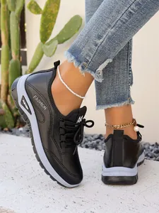 Close-up of women's black platform sneakers with lace-up detail and fashion logo