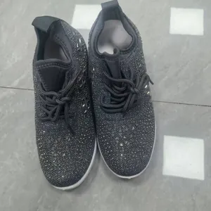 Gros plan de baskets grises pour femmes ornées de strass brillants avec un design à lacets
