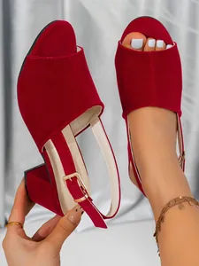 Detailed view of red suede block heel sandals featuring an elegant gold metal buckle
