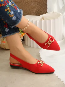 Detail of red suede pointed-toe slingback flats with decorative gold buckle.