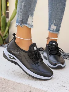 Close-up of women's black platform sneakers with comfortable lace-up design and breathable material.
