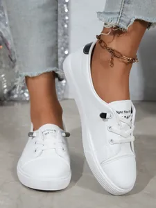 Detailed close-up of white casual sneakers featuring textured upper and black heel accent