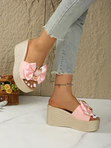 Elegante rosafarbene Plateau-Keilsandalen mit Satinschleife und schicker goldener Metallschnalle.