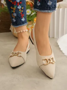 Detailed shot of beige suede pointed-toe slingback sandals featuring a gold chain.
