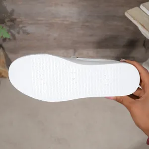 Detailed close-up showing the textured non-slip white rubber sole of a women casual sneaker