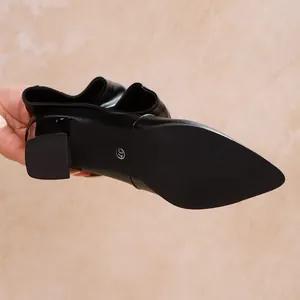 Macro detail of the anti-slip sole and block heel on a pointed black fashion boot