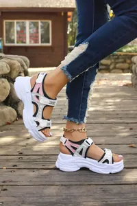 Close-up of women's sporty platform sandals featuring holographic accents and thick soles