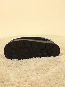 Detalle de la suela antideslizante de la zapatilla de nieve con patrón de copos.