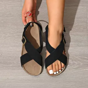 Stilvolle schwarze Kreuzsandalen mit verstellbaren goldfarbenen Schnallen auf dicker Sohle.