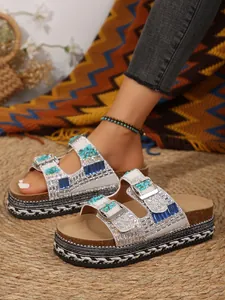 Close-up detail of luxury rhinestone platform sandals featuring turquoise stones and cork sole