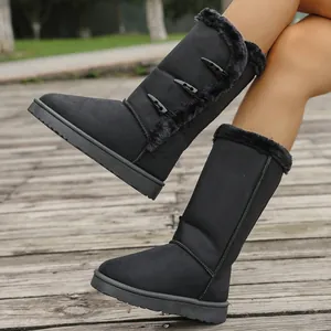 Detail view of black snow boots with horn buttons and faux fur trim for winter