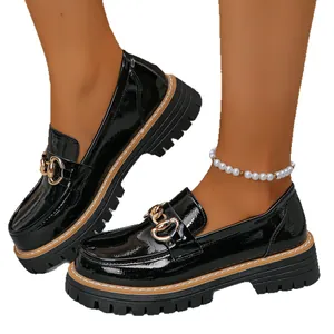 Women's black patent leather platform loafers with gold chain details on white background
