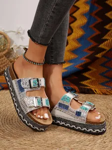 Detailed view of women's platform sandals with rhinestones and double buckles.