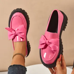 Premium pink patent leather loafers featuring oversized bow and thick platform black sole