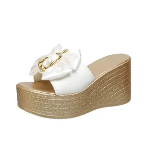 Elegante weiße Plateau-Sandaletten mit einer schicken Satinschleife und Goldschnalle.