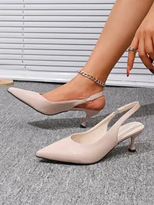 Close-up van nude slingbacks met spitse neus en kittenhak die de details laten zien