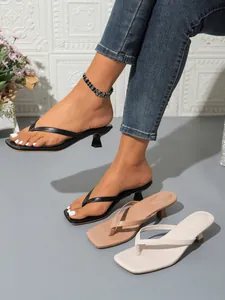 Detail view of women's square toe thong sandals with thin high heels in black, nude and white.