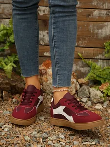 Retro sneakers in bordeaux en wit voor dames, gedragen op grind in een buitenomgeving