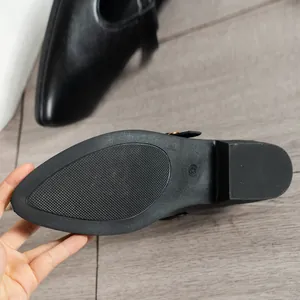 Close-up detail of the durable anti-slip rubber sole on women's black loafers