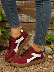 Gedetailleerd overzicht van vintage bordeaux en witte sneakers op de voeten