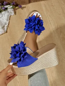 Gros plan du décor floral bleu sur des sandales à plateforme compensées dorées