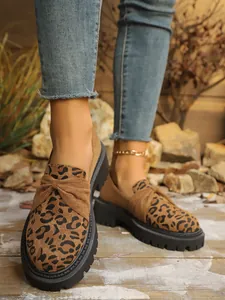 Close-up detail of leopard print suede loafers featuring a chunky black platform sole